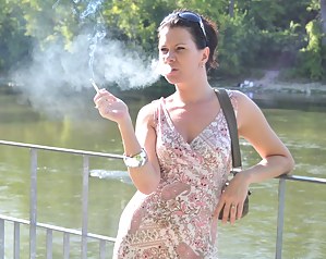 Brunette babe smoking at the riverside
